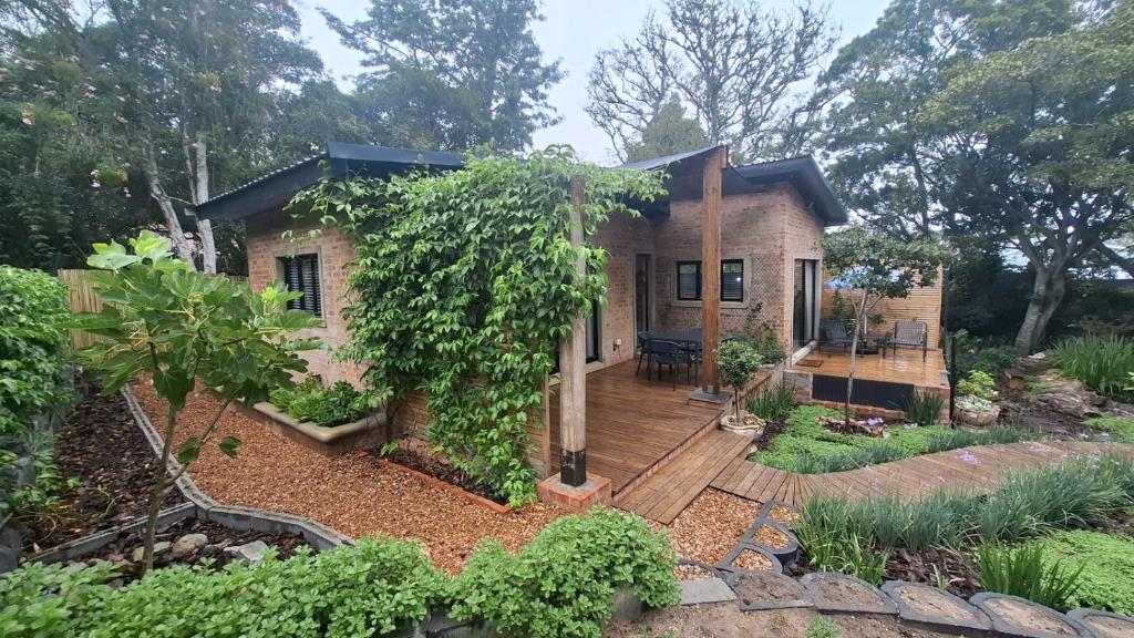 a small brick house with a wooden deck at Pond Cottage in Knysna
