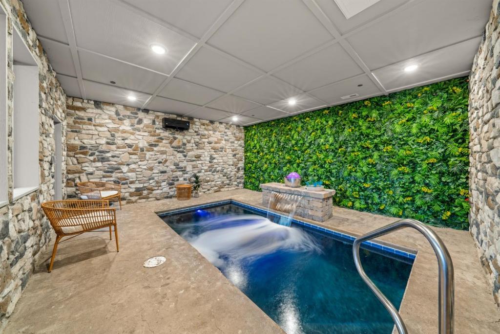 a swimming pool in a room with a green wall at Indoor Pool Hot Tub, Pets Welcome, Arcade Games - Sleeps 14 in Pigeon Forge