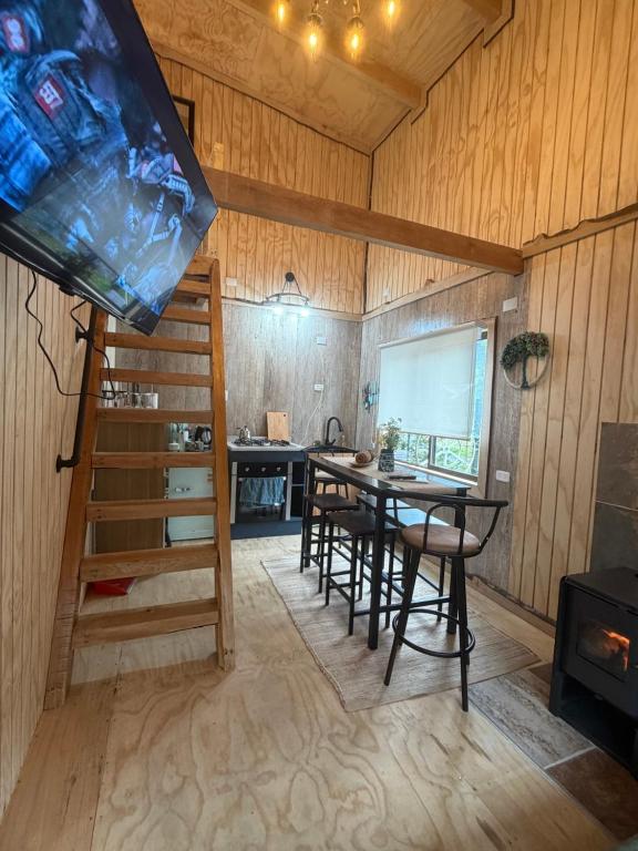a dining room with a table and a stove at Tiny House A & M Chaiten in Chaitén