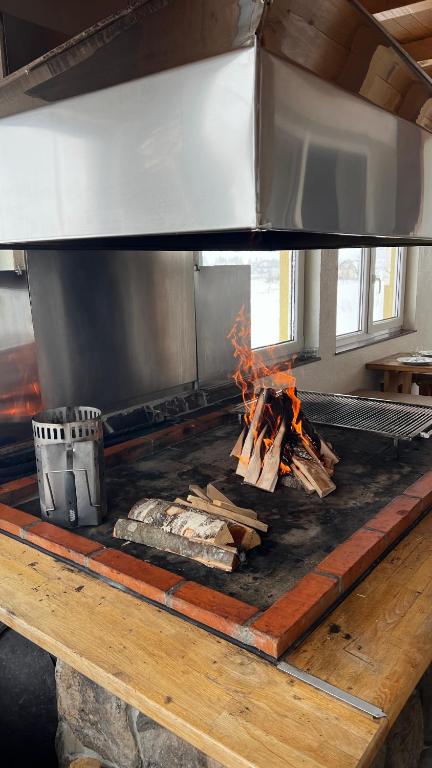 a grill with a pile of wood and fire at Kuća za odmor IVKOVIĆ in Kupres