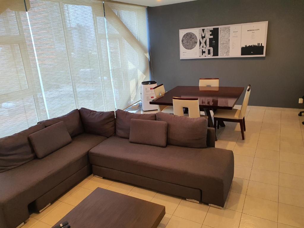 a living room with a couch and a table at Lujoso Penthouse en la Roma in Mexico City