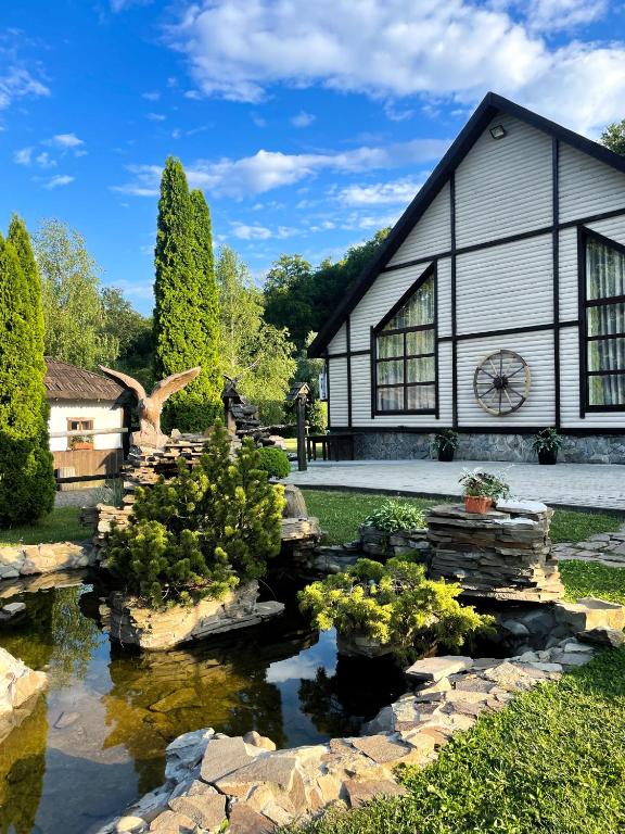 a house with a pond in front of it at Orlyne Gnizdo in Chernivtsi