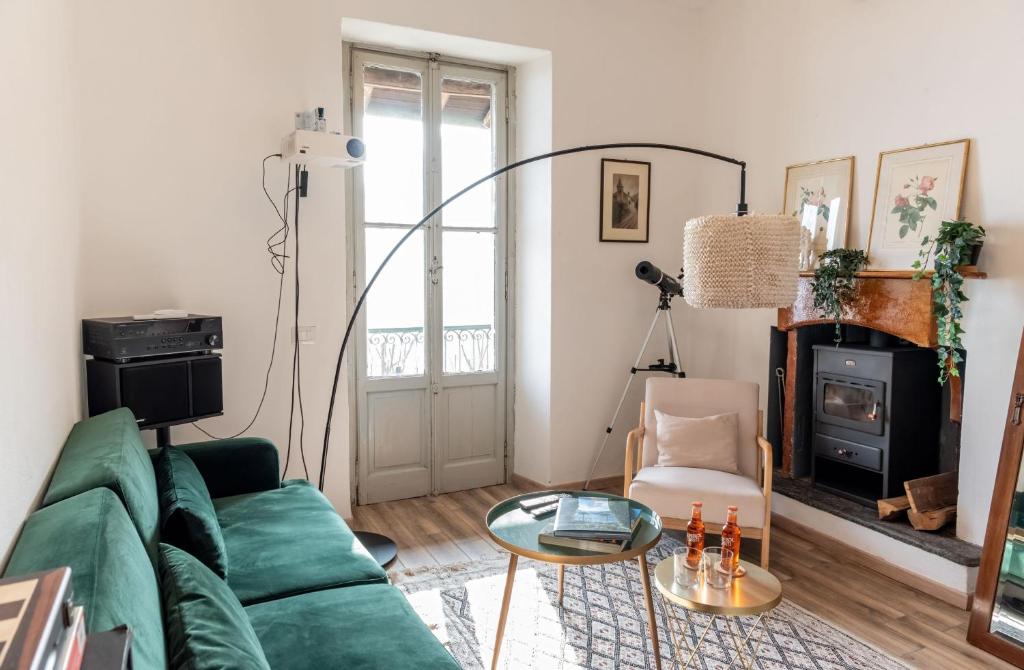 a living room with a green couch and a fireplace at Panoramic Stone Retreat - Menaggio by LoveComo in Menaggio