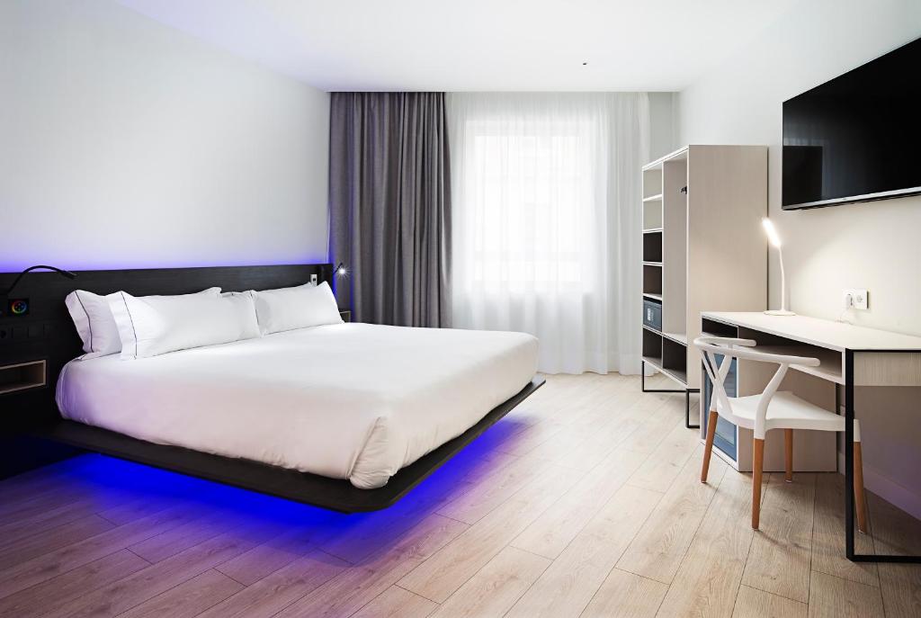um quarto com uma cama e uma secretária com um computador em B&B HOTEL Madrid Centro Puerta del Sol em Madri