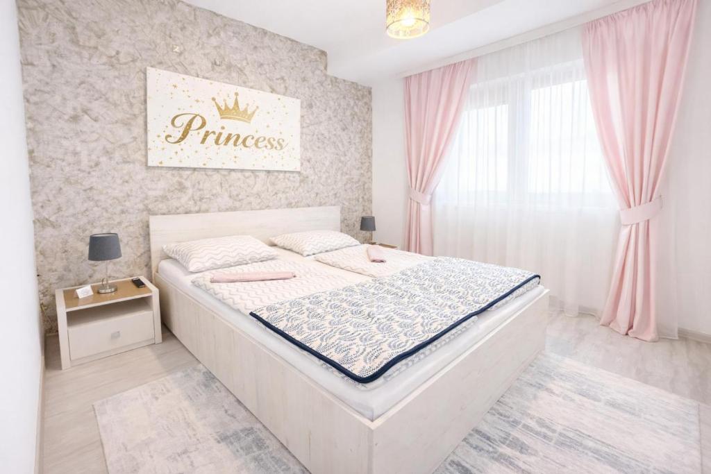 a bedroom with a large white bed with pink curtains at Princess Cozy Home Casy in Timişoara