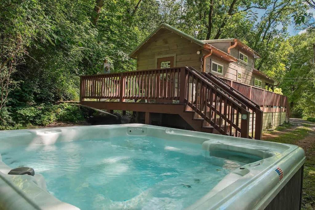 a hot tub with a deck and a house at Ryon Tiny Home Cabin City-side Rustic Retreat in Chattanooga
