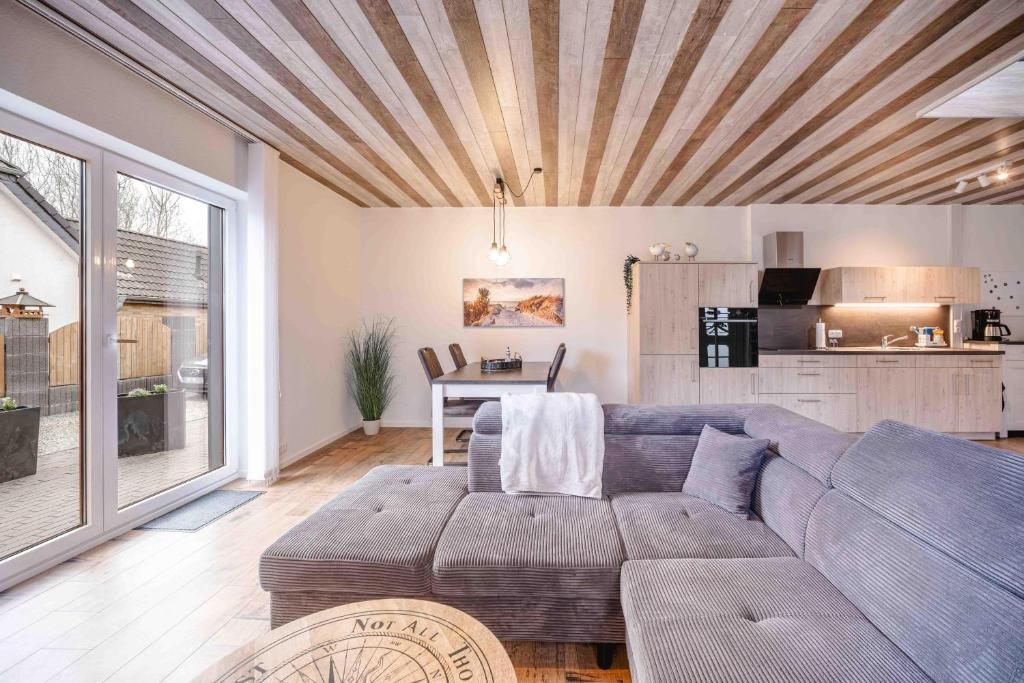 a living room with a couch and a kitchen at Haus Sonnengelb in Taarstedt