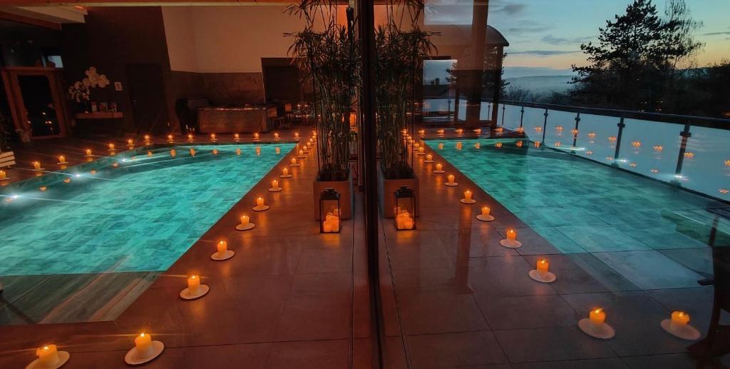 a swimming pool with candles and lights on a building at L’Antre d’Eux in Rémelfing