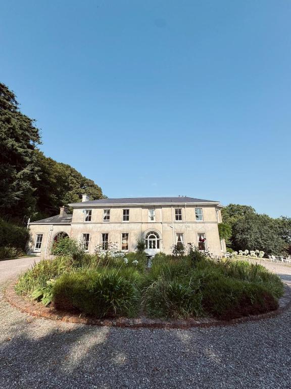 a large house with a lot of plants in front of it at Courtyard Apartament in Ballymore