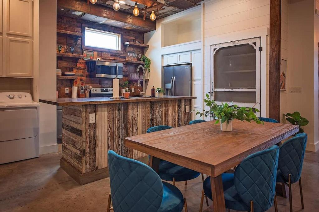 a kitchen with a wooden table and blue chairs at The Frothy Flat- A Bunny Slippers Optional Destination in Chattanooga