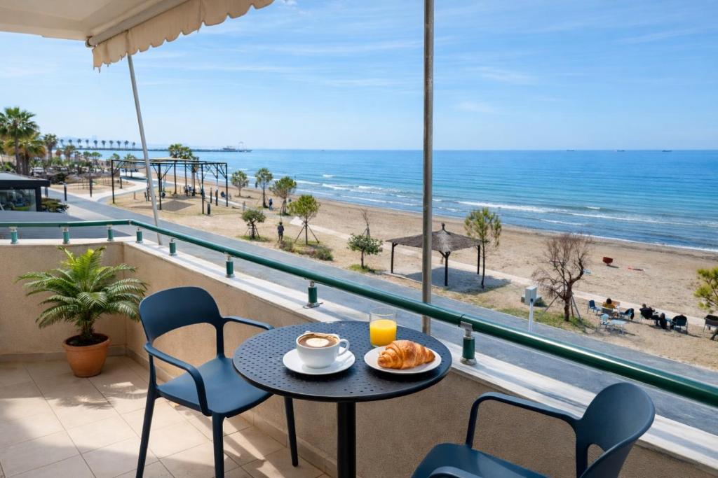 a table with a plate of food on a balcony overlooking the beach at DoR Stay Seaside in Durrës