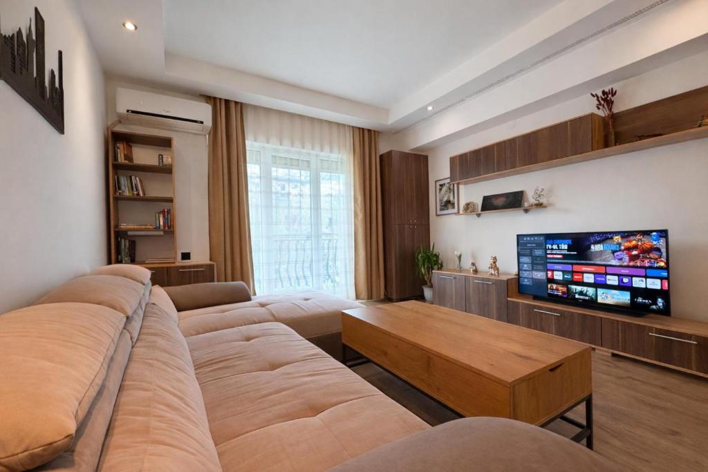 a living room with a large couch and a tv at Salvatore Apartment #BucharestAirport in Ştefăneştii de Sus