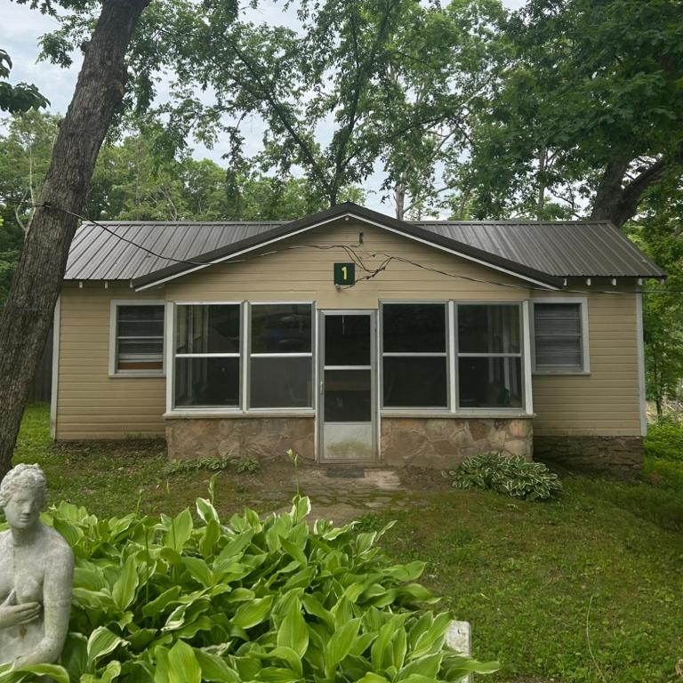 a house with a statue in front of it at Cabin #1 on Meramec River in Steelville
