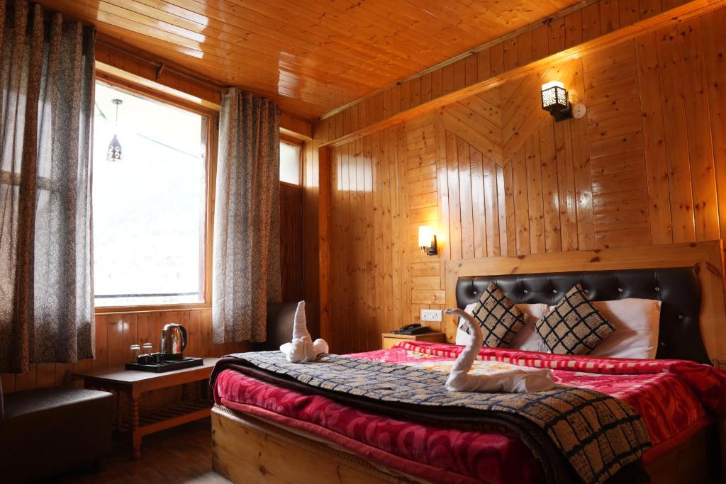 a bedroom with a bed with two animals on it at The Himalayan Drift Cottages in Vashisht
