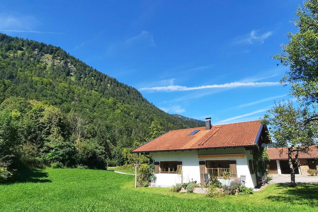 a house with a red roof on a green field at Ferienhaus Labenbach in Sachrang