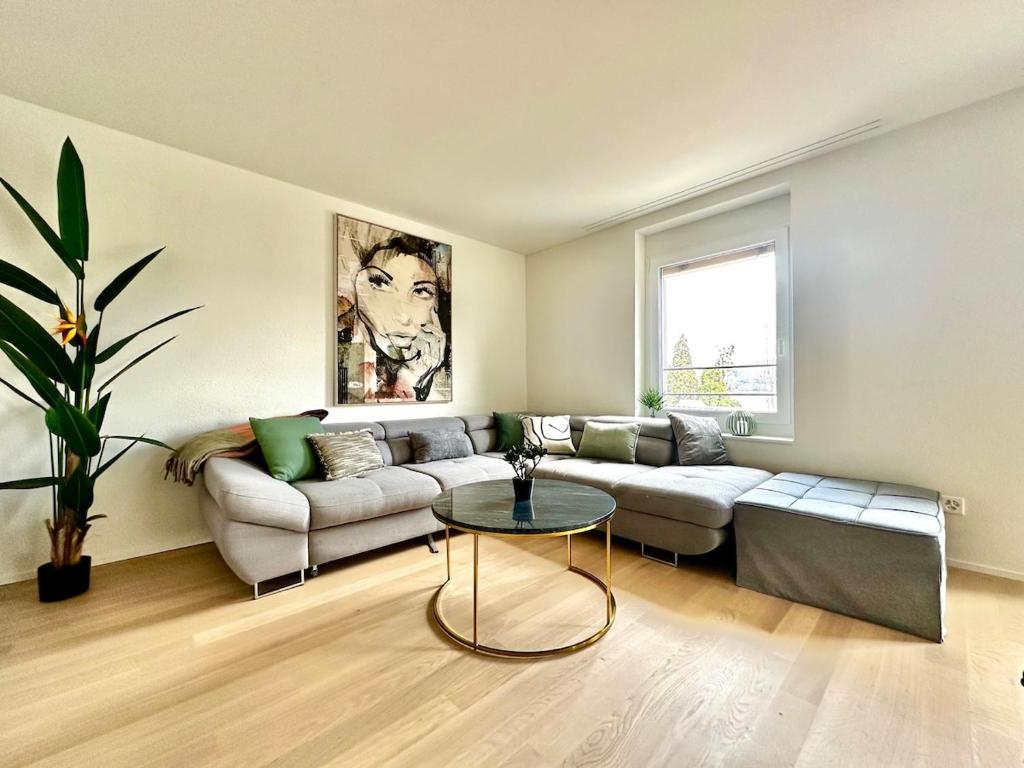 a living room with a couch and a table at Seeblick Wohnung in Wollishofen in Zurich