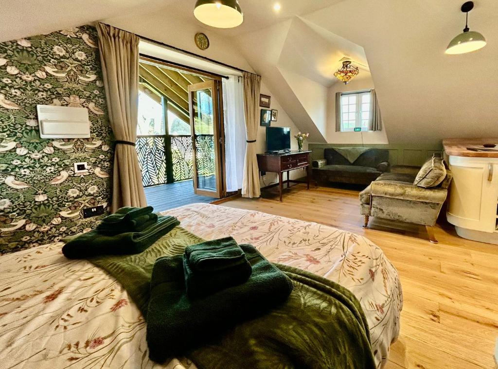 a bedroom with a large bed and a living room at The Coach House in Torpoint
