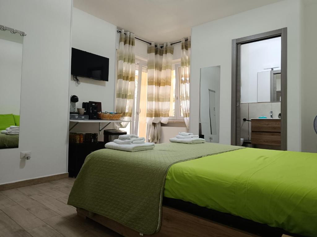 a bedroom with a green bed with towels on it at Mar&Mar in Alghero