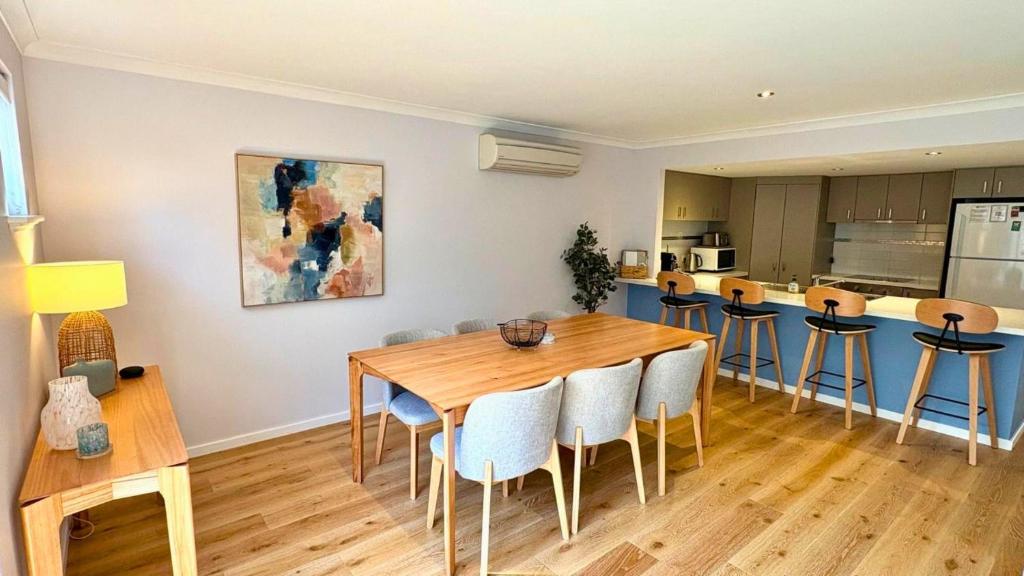 a dining room with a wooden table and chairs at SixtySix at Cape View in Broadwater