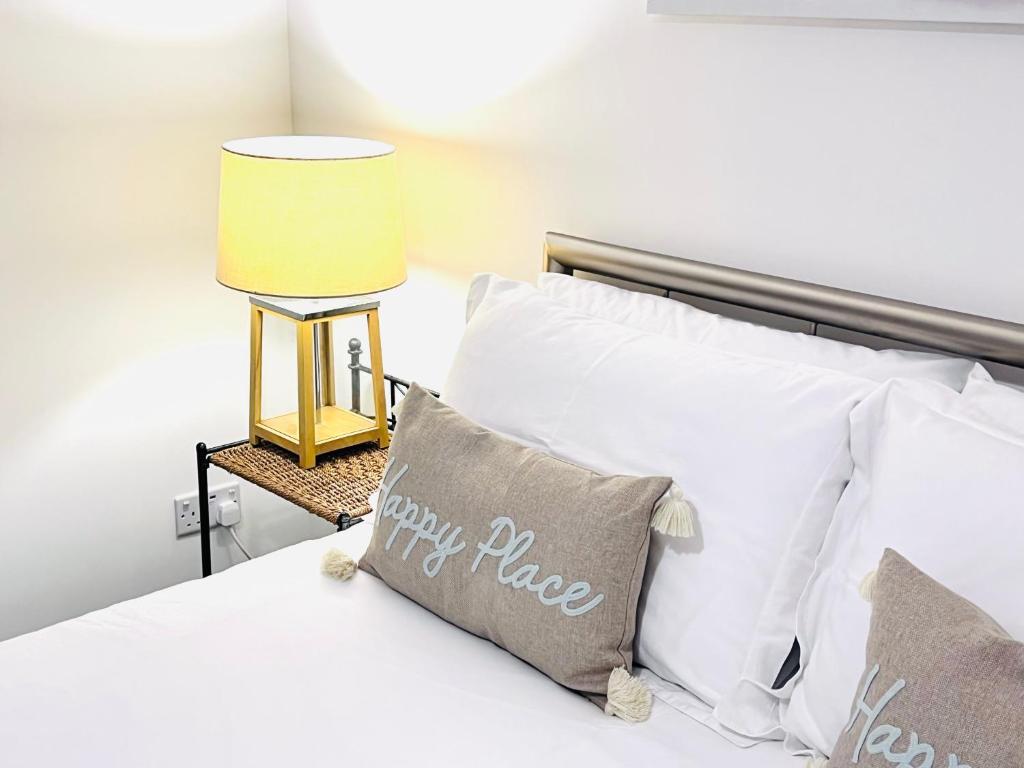 a bedroom with a bed with white pillows and a lamp at River house in Birnam