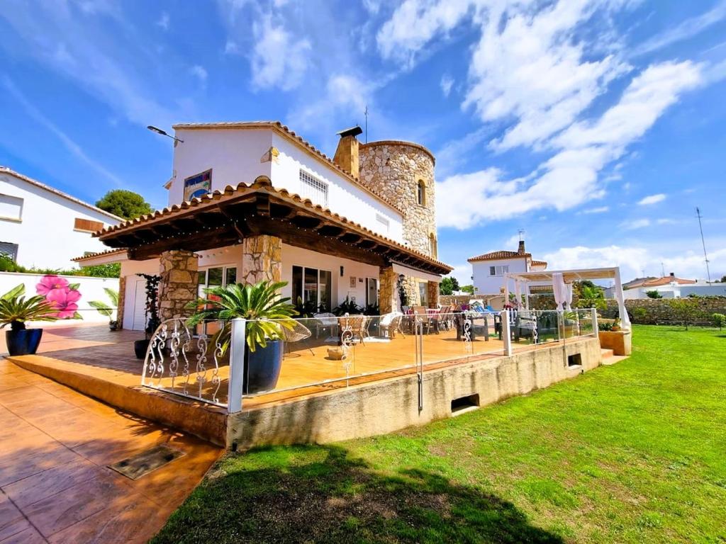 a house with a patio in front of it at Villa Gigi Torre del Sol - 14-18 pers - Coma-Ruga in El Vendrell