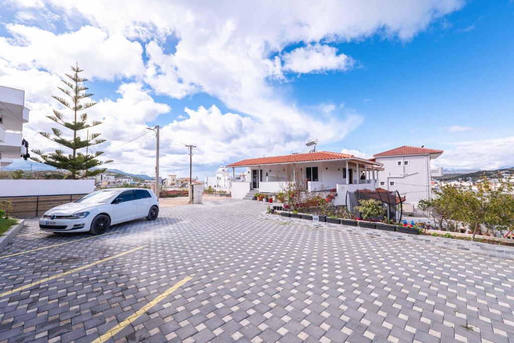 a white car parked in a parking lot at Velora Apartments Ksamil in Ksamil