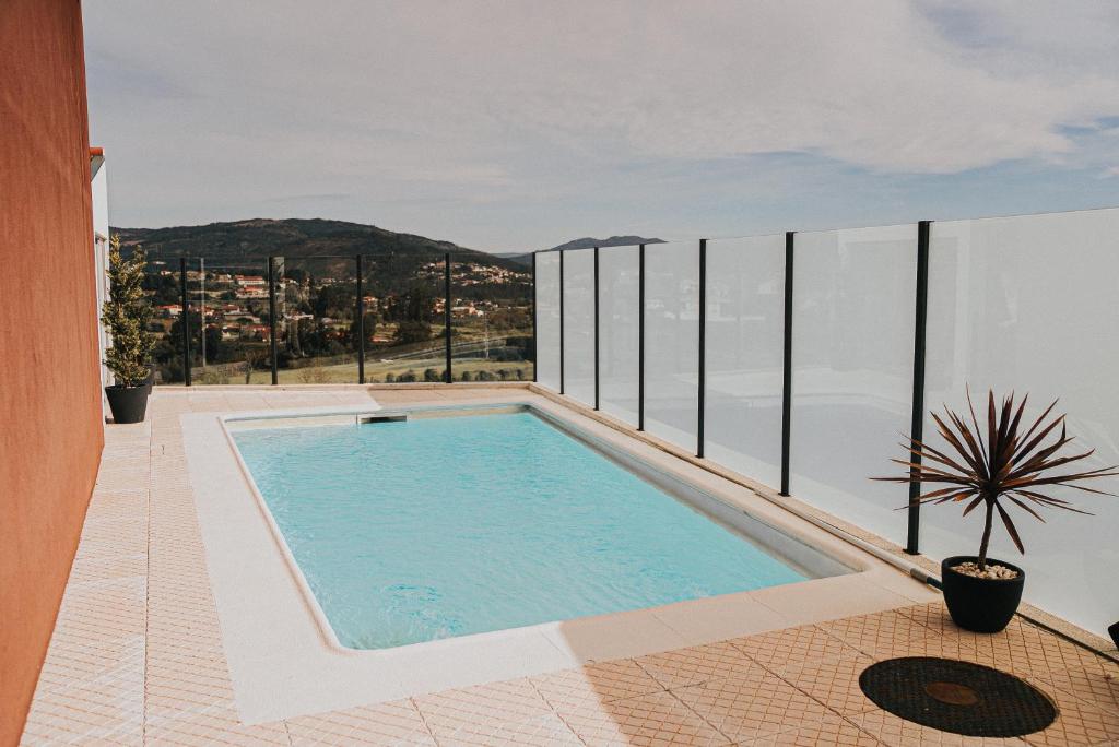 a swimming pool on the balcony of a house at Casa Moinho Vedro in Quintiães