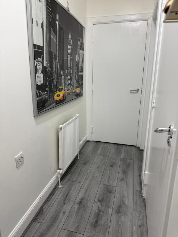 a hallway with a white door and wooden floors at Zikach Apartment Near to Glasgow Airport in Renfrew