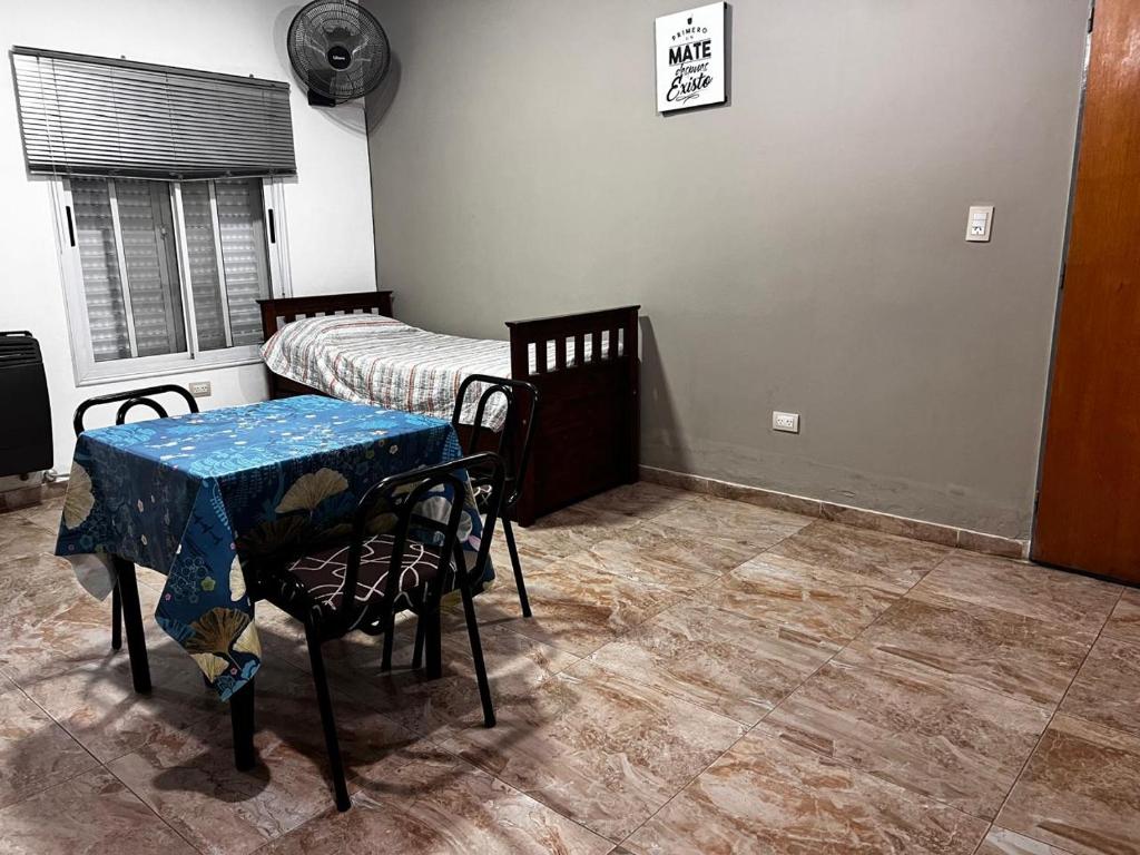 a room with two beds and a table and chairs at El rincon del viajero deptos in San Francisco del Monte de Oro