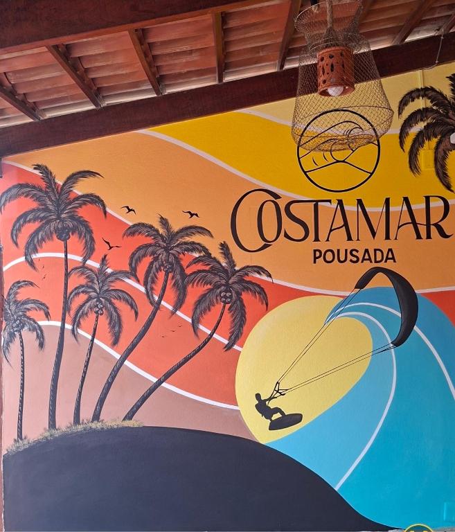 a sign for a resort with a man on a surfboard at Costamar Galinhos in Galinhos