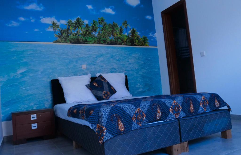a bed in a room with a view of the ocean at Appartement dépaysante T1B in Tarrafal