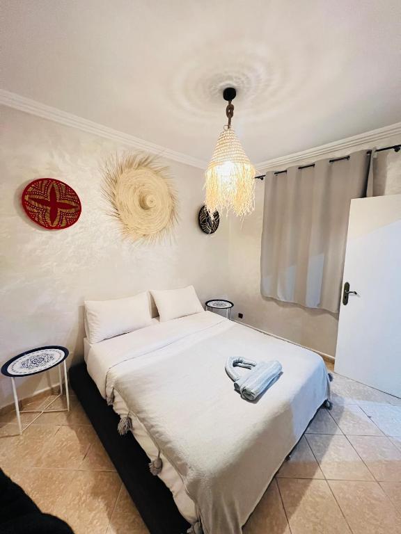 a bedroom with a large bed with a chandelier at sun house tamraght in Tamraght Ouzdar