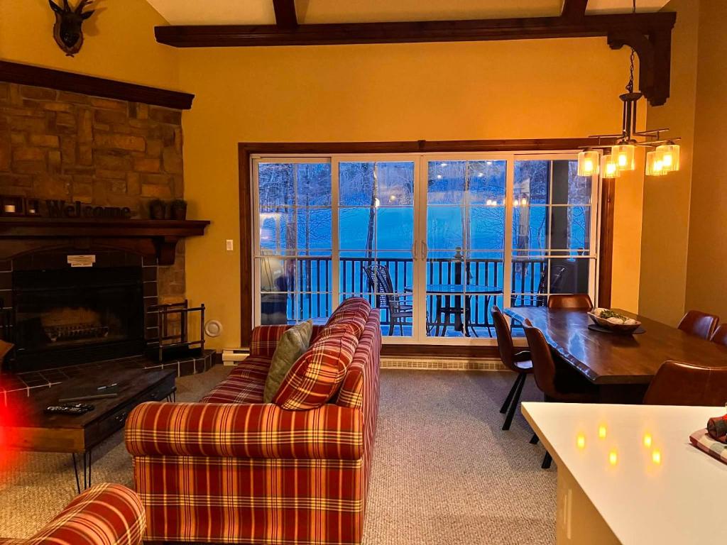 a living room with a couch and a table and a fireplace at Manoir Signature in Mont-Tremblant