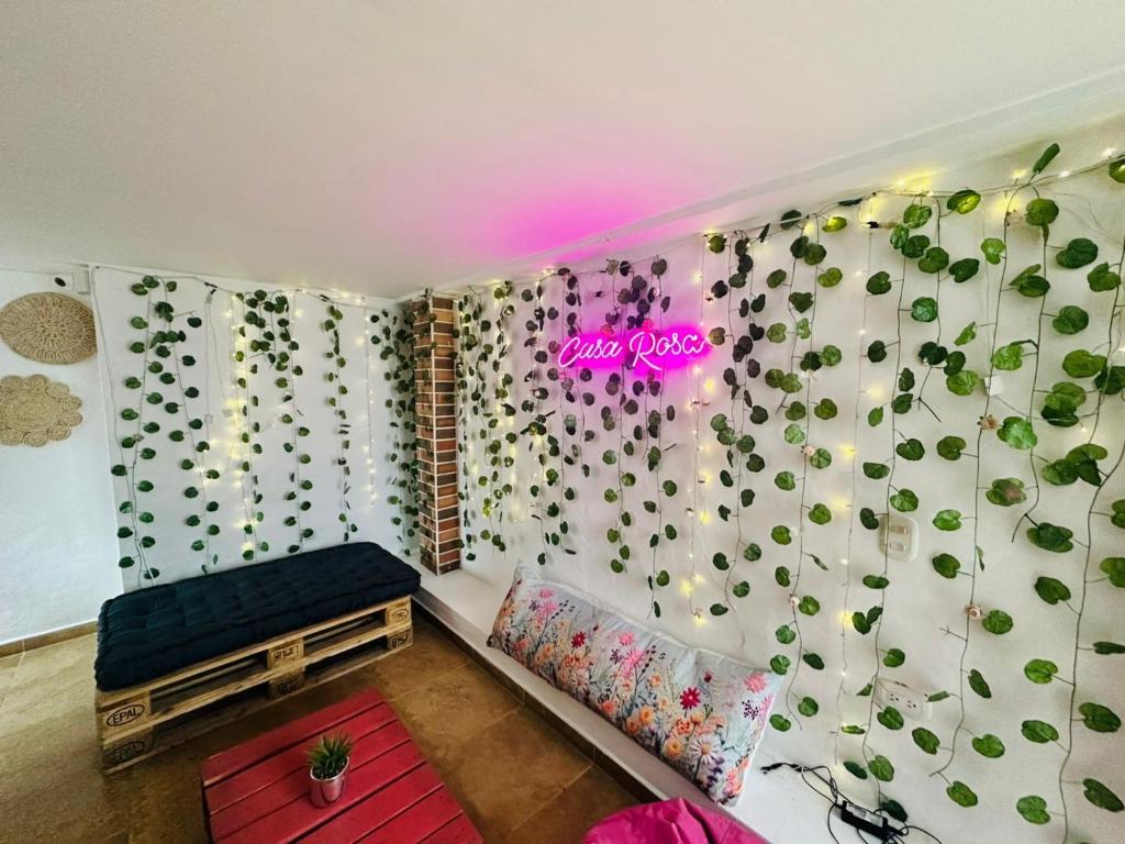 a room with a wall covered in potted plants at Aloja-T Hostal Jericó in Jericó