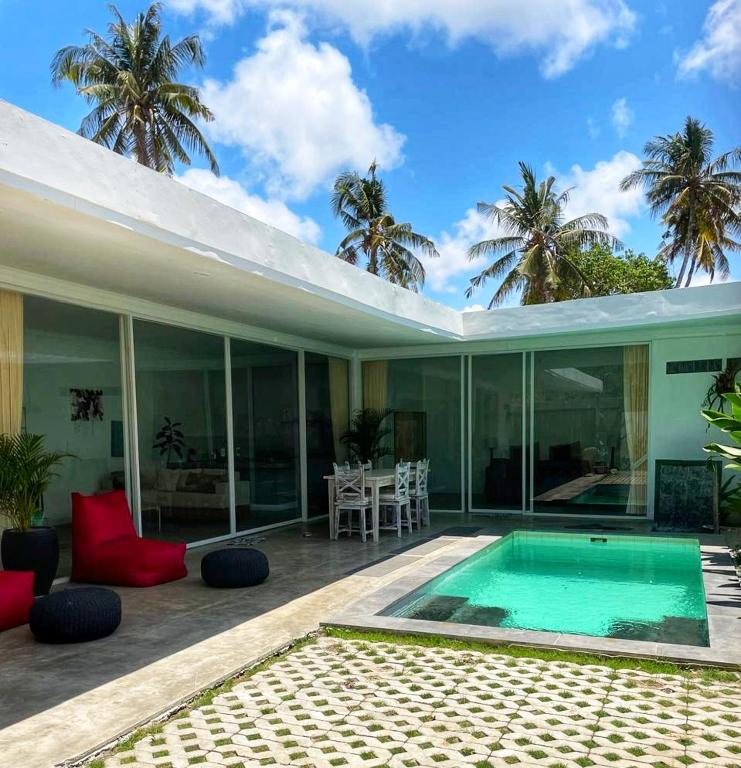 a house with a swimming pool and a patio at Bliss Villa Central Kuta in Kuta Lombok