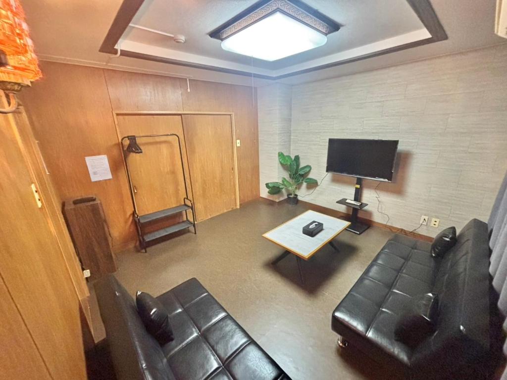 a living room with a couch and a television at HoTTOSTAY矢田 in Nagoya