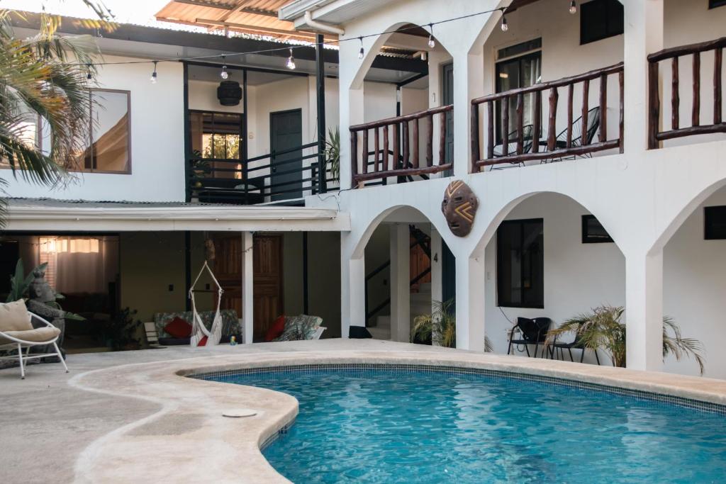a villa with a swimming pool in front of a house at Nosara Hotel Playa Garza in Garza