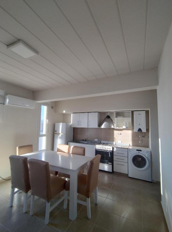 a kitchen with a table and chairs in a room at Depto tranquilo y equipado cerca del mar in Puerto Madryn