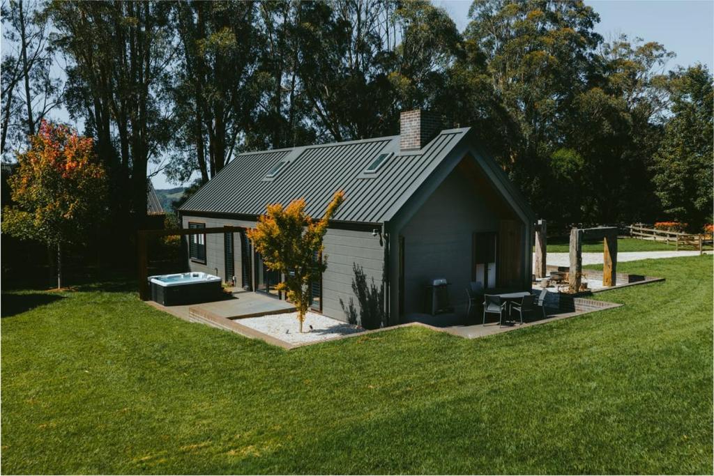 a small house in a field of grass at The Mist, Luxury Farm w Fireplace & Hot tub in Exeter