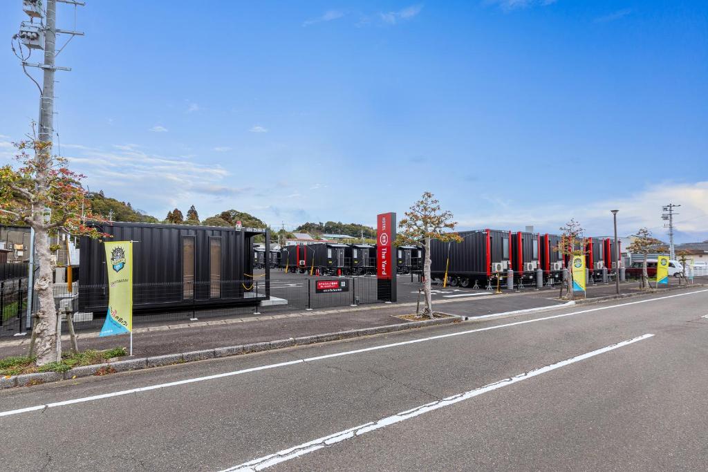 a street with a row of containers on the side of a road at HOTEL R9 The Yard Shintomi in Imabyū