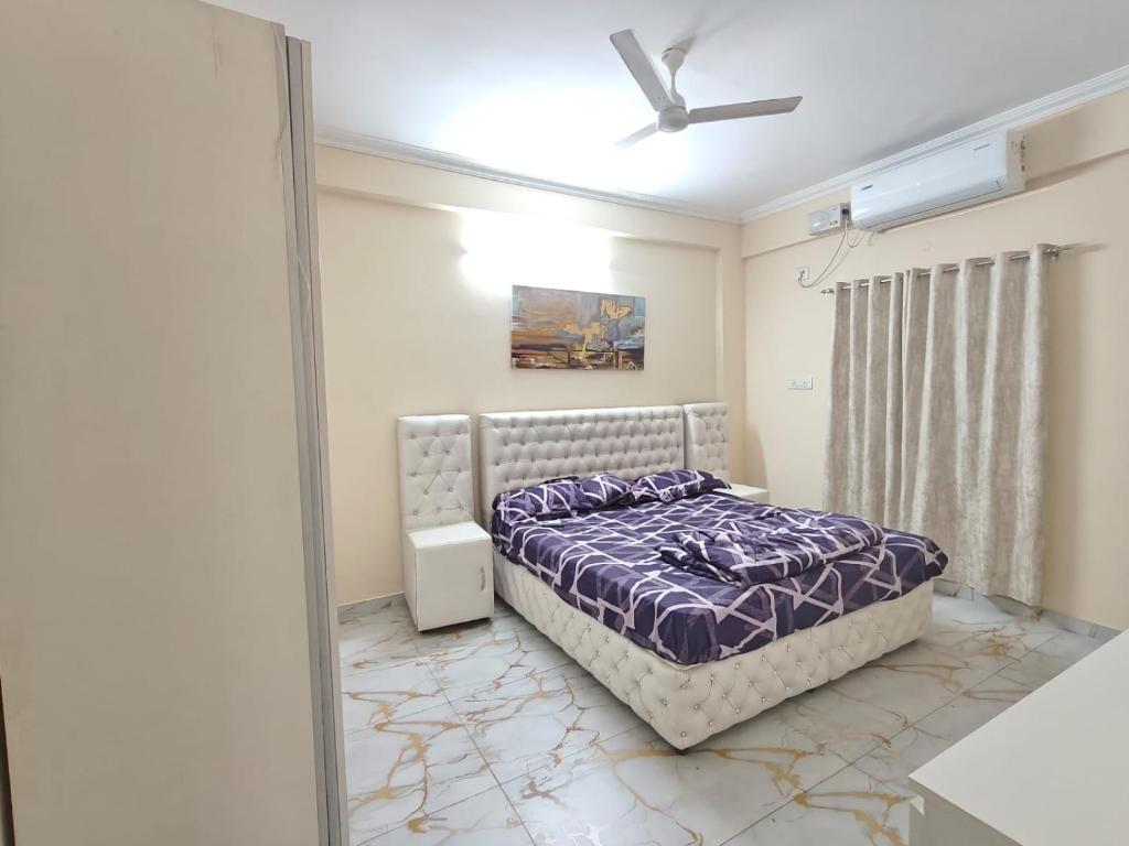 a bedroom with a bed and a ceiling fan at Sakez Homestays HH in Hyderabad