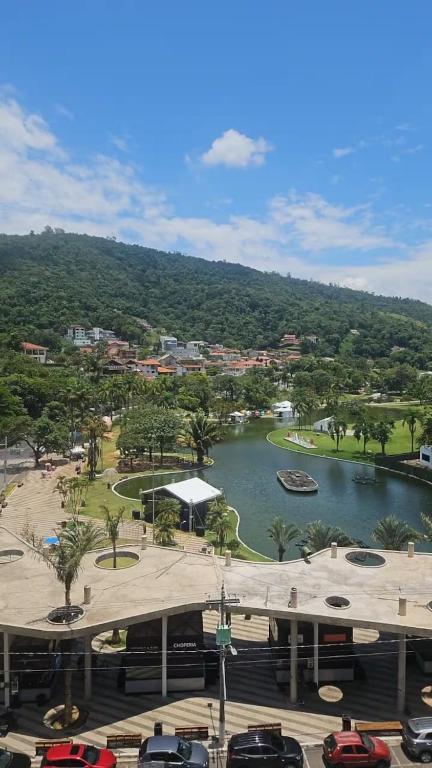 a view of a river with cars parked in a parking lot at Ap Centro - Wi-fi, Piscina, com Vista da Praça in Águas de Lindoia