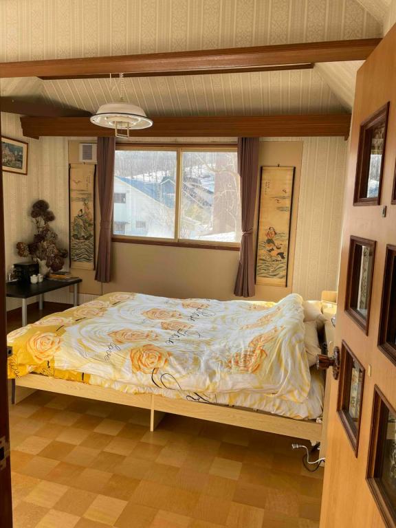 a bedroom with a bed in a room with a window at Nomad Gala Otaru in Otaru