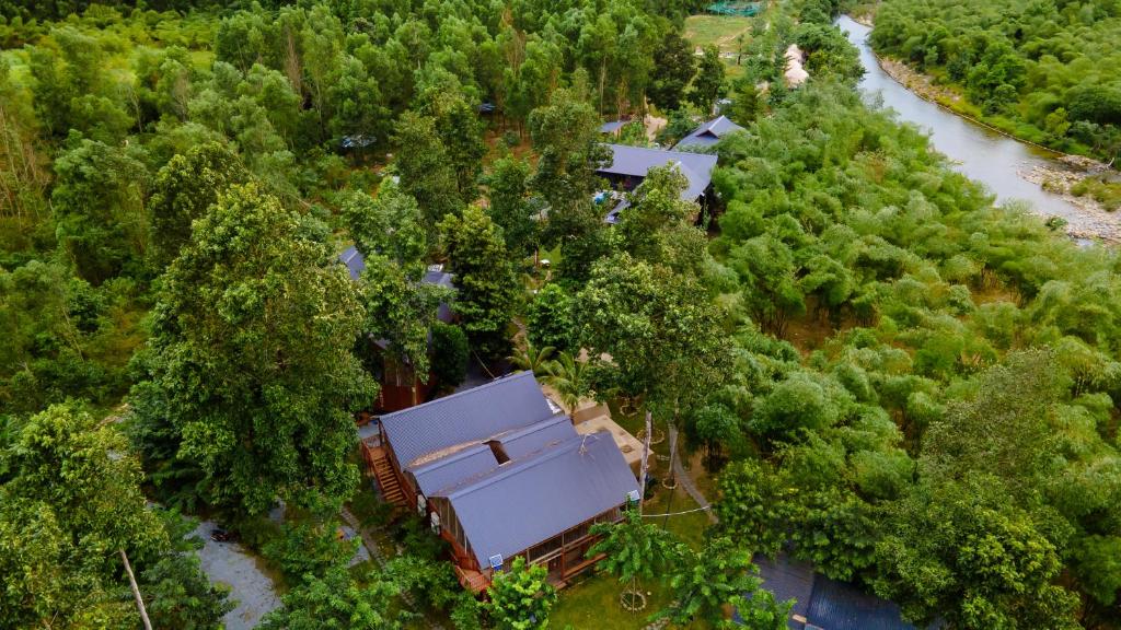 an aerial view of a house in the woods next to a river at Lạc Sanh Onsen Resort in Tuy Hoa