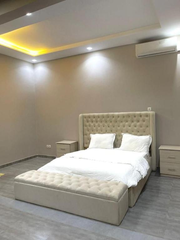 a bedroom with a large bed with white sheets and pillows at Goat1 in Dakar