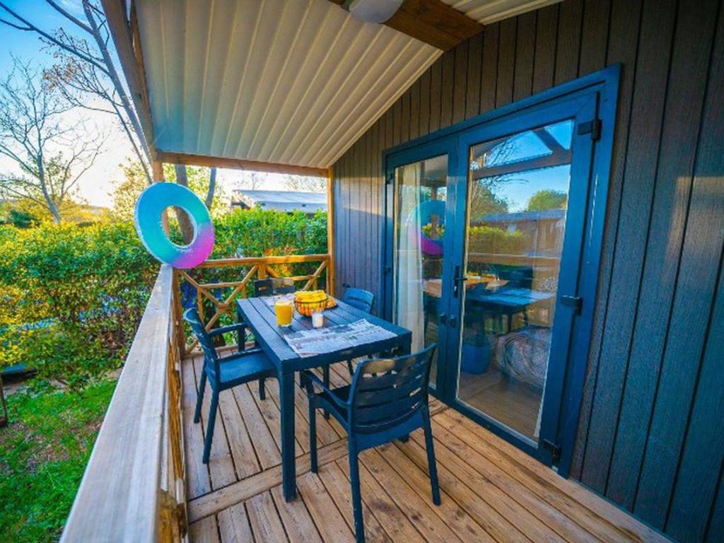 a patio with a table and chairs on a deck at Cottage avec clim - 4 pers. - API-1-52-2191 in Balaruc-les-Bains
