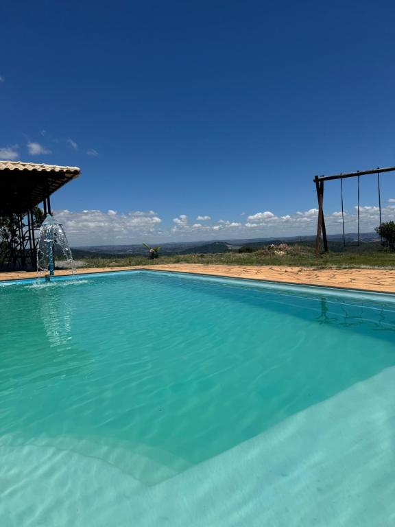 a large swimming pool with a clear blue sky at Sítio com piscina em bh mirante do Sol in Santa Luzia