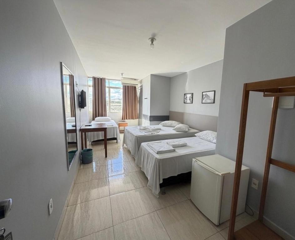 a hotel room with two beds and a mirror at Hotel Lords in Brasília