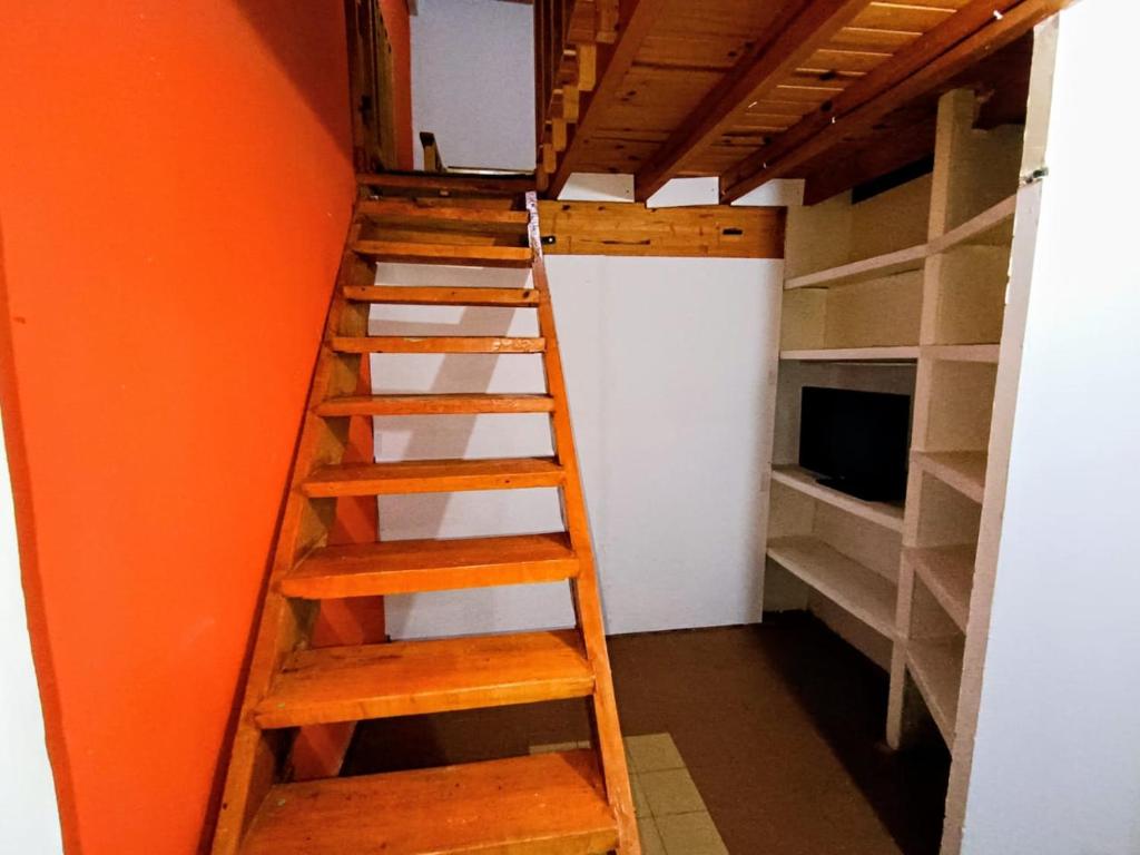 a ladder in a room with an orange wall at Departamento TERRA ANDRAY centro in Famatina