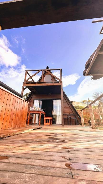 a house with a wooden floor and a wooden deck at Cabana Janela do Céu in Jaboticatubas